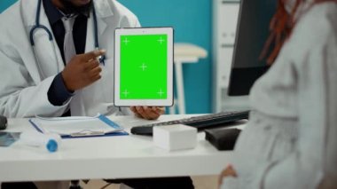 Tablet ekranında yeşil ekran şablonu kullanan erkek doğum uzmanı