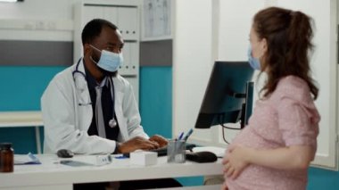 Hamilelik göbeği olan bir kadını muayene eden pratisyen.