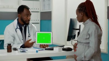 Yatay yeşil ekranlı dijital tableti tutan doktor