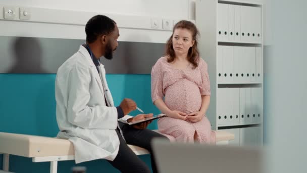 Ärztin im Gespräch mit zukünftiger Mutter im Kabinett — Stockvideo