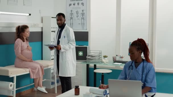 Médico masculino fazendo exame de check-up com paciente expectante — Vídeo de Stock