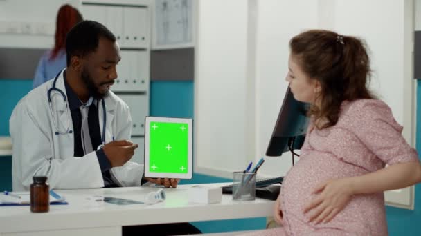 Pregnant woman and specialist looking at greenscreen — Stock Video