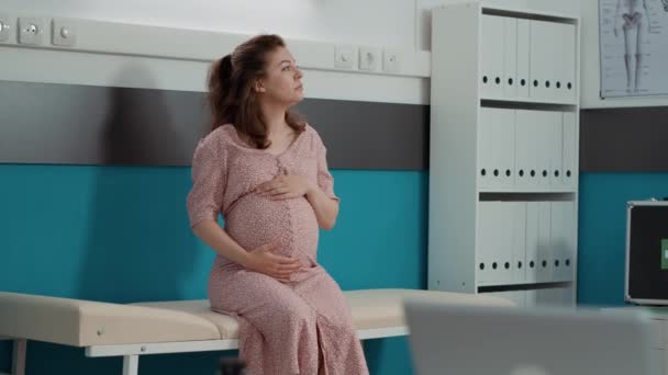 Porträt einer zukünftigen Mutter mit Babybauch auf Schrankbett — Stockvideo