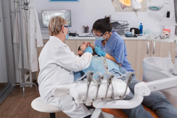 Специалист-ортодонт проверяет мужскую дантуру — стоковое фото