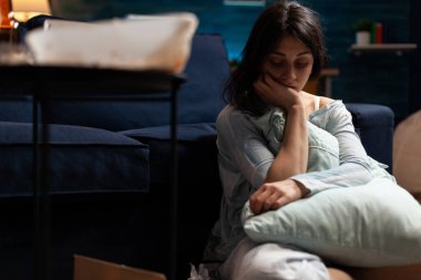 Evde acı ve yalnızlık çeken depresif biri.