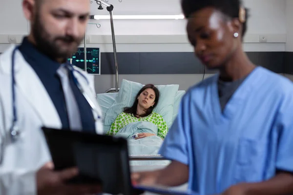 Patient sur le lit d'hôpital se sentant malade attendant que le médecin et l'infirmière lisent le diagnostic du comprimé digestif — Photo