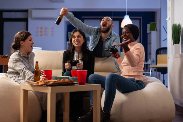 Felices compañeros de trabajo celebrando videojuegos ganan con bebidas —  Fotos de Stock