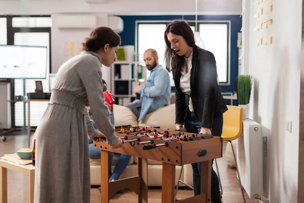 Diverse team of coworkers playing foosball game table match — ストック写真