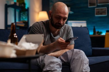 Akıllı telefon internetinde gezinen umutsuz, hayal kırıklığına uğramış kişi.
