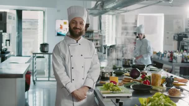 Портрет чоловічого шеф-кухаря, який дивиться на камеру на професійній кухні — стокове відео