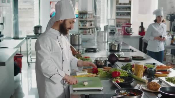 Giovane chef taglio aglio naturale spicchio sul tagliere — Video Stock