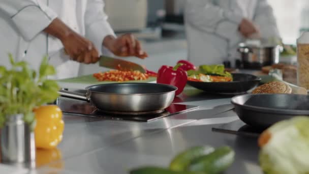 Erkek aşçı restoran mutfağında doğranmış dolmalık biber hazırlıyor. — Stok video
