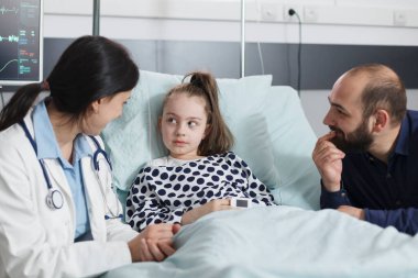 Mutlu gülümseyen baba başarılı bir iyileşme sürecinden bahseden pediatrist uzmanına özen gösteriyor.