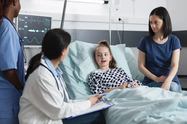 Centro de atención médica pediatra experto en hablar con la niña recuperada sobre el esquema de tratamiento exitoso. —  Fotos de Stock