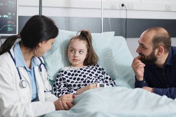 Mutlu gülümseyen baba başarılı bir iyileşme sürecinden bahseden pediatrist uzmanına özen gösteriyor.