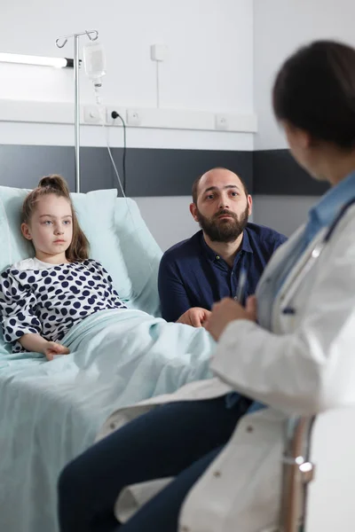 Especialista pediatra del hospital de salud explicando a padre preocupado síntomas de la enfermedad hija —  Fotos de Stock