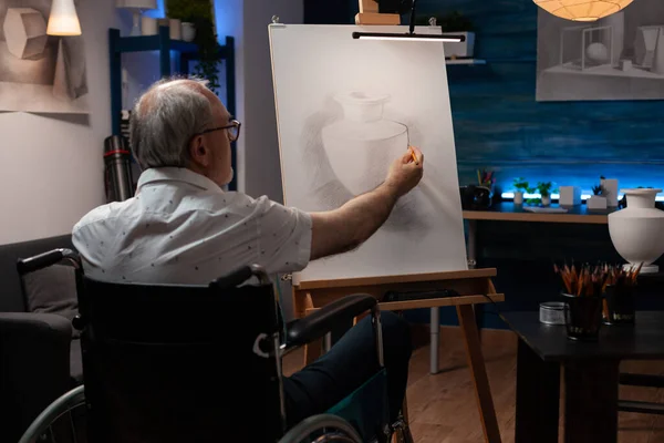Senior man konstnär med hjälp av rullstol ritning original penna ritning av stilleben vas känsla kreativ på staffli — Stockfoto