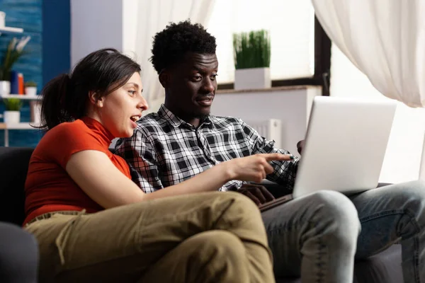 Joyful jovem casal multiétnico olhando para a tela do computador — Fotografia de Stock