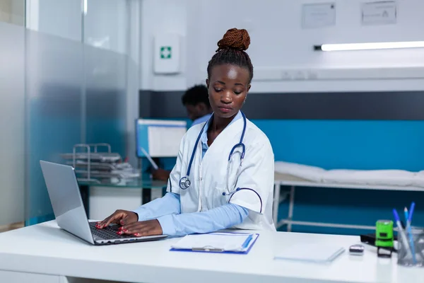 Médico especialista em clínica usando computador para verificar registros de medicação — Fotografia de Stock