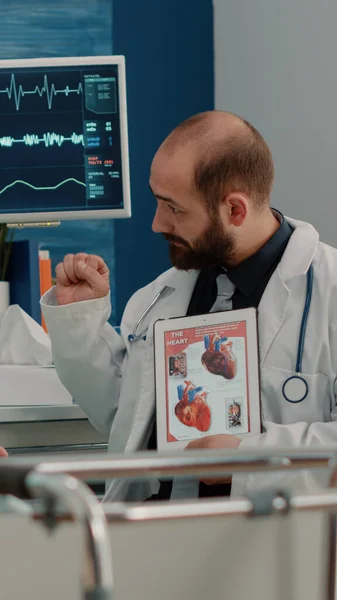 Lékař ukazující kardiovaskulární obraz na tabletu nemocnému pacientovi — Stock fotografie