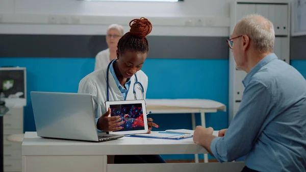 Médecin noir tenant l'animation du virus sur tablette — Photo