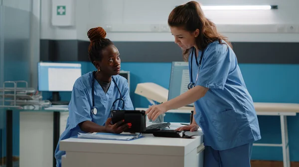 Läkarteam med sjuksköterskor som använder surfplatta med pekskärm — Stockfoto
