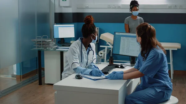 Médecin et infirmière travaillant avec un document de prescription pour le patient — Photo