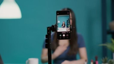 Asyalı kadın blogcu yayın ekipmanları ile makyaj dersi kaydediyor