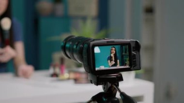 Makyaj fırçasını videoda inceleyen genç etken