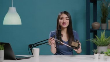 Asyalı yaratıcının POV video kayıt kamerasında tripod başını gözden geçiriyor
