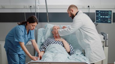 Doktor ve hemşire ağır nefes alan hasta kadına yardım ediyor.