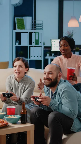 Coworkers playing video games with controllers on console — Stock Photo, Image