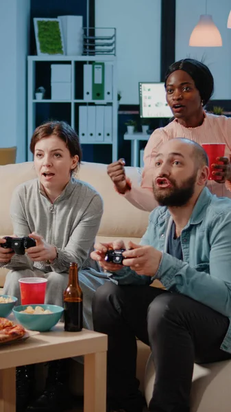 Diverse group of workmates using joysticks to play video games — Stock Photo, Image