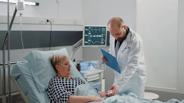 Läkare och sjuksköterska gör konsultation med oximeter för sjuk kvinna — Stockfoto