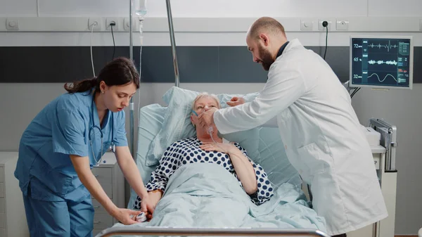 Läkare och sjuksköterska hjälper sjuk kvinna andas tungt — Stockfoto