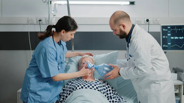 Lékař a sestra pomocí kyslíkové trubice a oximetru na nemocného pacienta — Stock fotografie