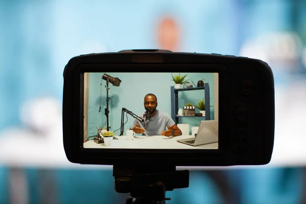 Selektivní zaměření na zadní obrazovku dslr filmování vliv sedí za stolem mluvit na profesionální mikrofon — Stock fotografie