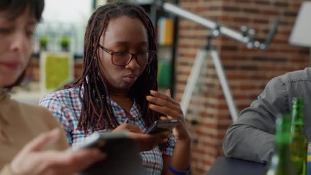 Multietnisk grupp vänner sitter tillsammans och använder smartphone — Stockvideo