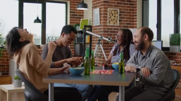 Diverso grupo de amigos riendo mientras juegan juego de mesa — Vídeos de Stock