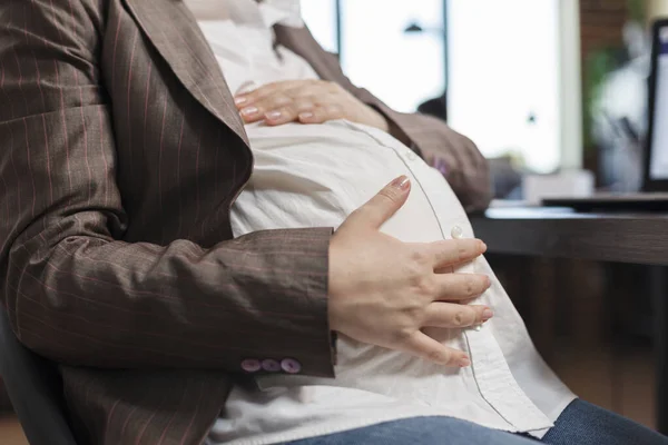 Close up de mulher grávida tocando colisão bebê enquanto no escritório da empresa local de trabalho. — Fotografia de Stock