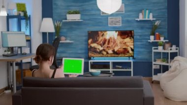 Yeşil ekranlı dijital tabletli genç bir kadının Webinar izlediği statik tripod görüntüsü.