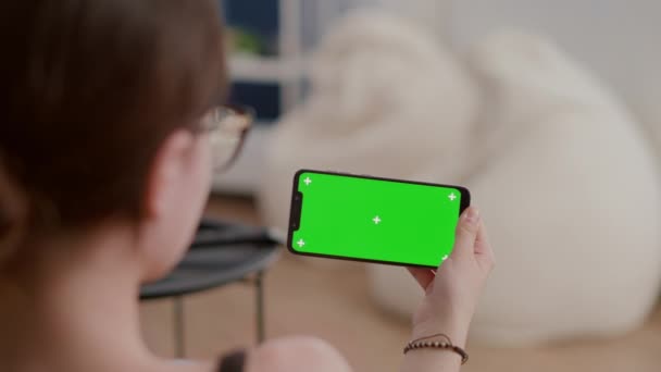 Крупный план молодой женщины, держащей в руках горизонтальный смартфон с зеленым экраном — стоковое видео