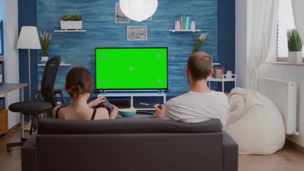Un par de jugadores pasan tiempo libre jugando rápido juego de acción de consola en la pantalla verde — Vídeo de stock