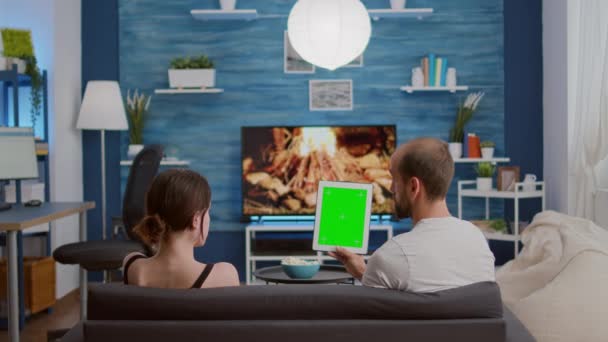 Yeşil ekran ile dikey dijital tablet taşıyan çiftin etkileyici vlog hakkında konuştuğu statik tripod görüntüsü — Stok video