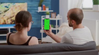 Yeşil ekranlı dikey akıllı telefonu olan çift sosyal medya içeriği hakkında konuşuyor