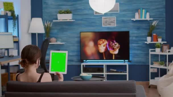 Girl holding vertical digital tablet with green screen in online conference or group video call — Stock video