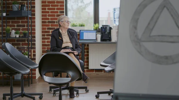 Psychologist sitting in circle with chairs and waiting on people at aa group meeting