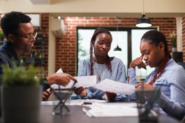 Afrika kökenli Amerikalı iş adamları iş yerinde mali stratejiyi tartışıyor.
