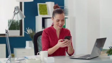 Satış danışmanı masadaki akıllı telefondan internete göz atıyor.