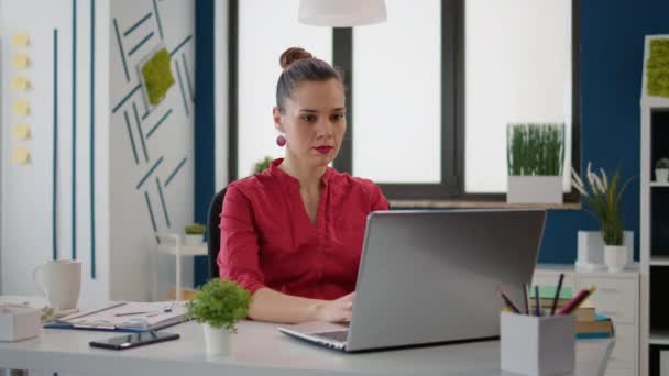 Portret van een zakenvrouw die werkt met verkoopgrafieken op laptop — Stockvideo